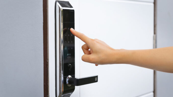 Close-up hand pressing keywords to lock and unlock door - Door access control keypad with keycard reader